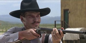 A scene from a classic Western film, featuring a cowboy wielding a lever action rifle in an iconic pose that embodies the spirit of the American frontier.